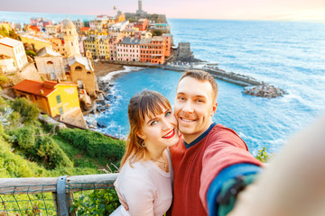 Tourists happy couple taking selfie photo of Vernazza, national park Cinque Terre, Liguria, Italy, Europe. Concept travel