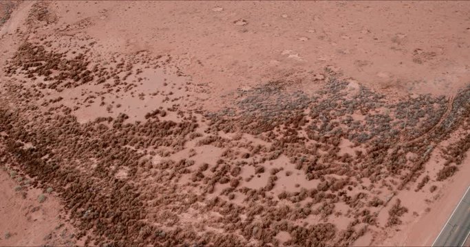 Aerial Lockdown: Orange Tinted, Desert Ground With Rocks Covering in Monument Valley, UT
