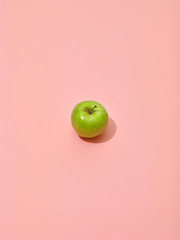 green apple on pink background