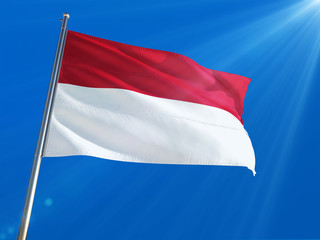 Fototapeta na wymiar Indonesia National Flag Waving on pole against deep blue sky background. High Definition