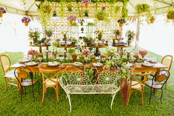 Wedding Setup. Banquet with table and chairs and cake tables with sweet. Decoration, flowers, ware, glass