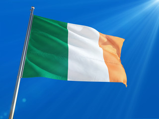Ireland National Flag Waving on pole against deep blue sky background. High Definition