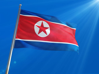 North Korea National Flag Waving on pole against deep blue sky background. High Definition