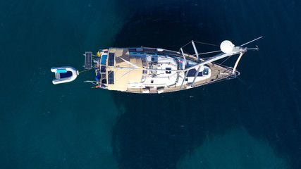 Aerial drone bird's eye top view photo of luxury yacht with wooden deck docked in deep blue waters...