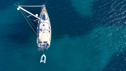 Aerial drone bird's eye top view photo of luxury yacht with wooden deck docked in deep blue waters...