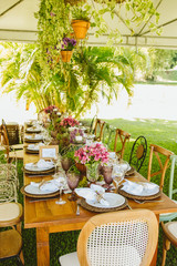 Wedding Setup. Banquet with table and chairs. Decoration, flowers, ware, glass