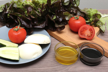 Salad mozzarella cheese tomatoes balsamic vinegar olive oil on a wooden board. Fresh food for diet product