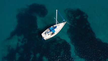 Aerial top view photo of fit man practising wind surfing in exotic open ocean bay with crystal clear emerald sea