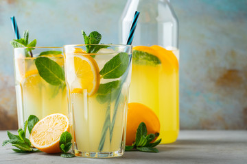Two glass with lemonade or mojito cocktail with lemon and mint, cold refreshing drink or beverage...