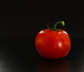 Fresh tomato on black background