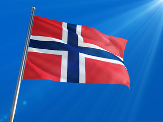 Norway National Flag Waving on pole against deep blue sky background. High Definition