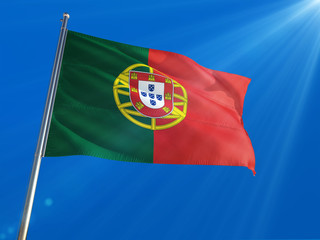 Portugal National Flag Waving on pole against deep blue sky background. High Definition