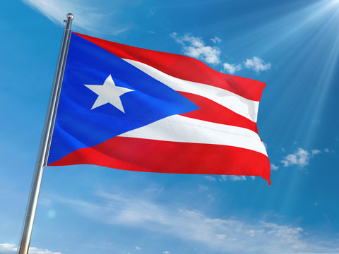 Puerto Rico National Flag Waving on pole against sunny blue sky background. High Definition