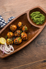 Fototapeta na wymiar Tandoori aloo are roasted potatoes with Indian spices. It's a party appetiser served with green chutney. selective focus