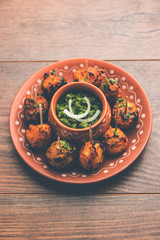 Tandoori aloo are roasted potatoes with Indian spices. It's a party appetiser served with green chutney. selective focus