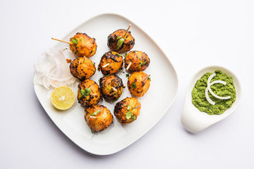 Tandoori aloo are roasted potatoes with Indian spices. It's a party appetiser served with green chutney. selective focus