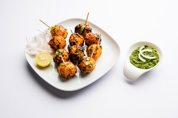 Tandoori aloo are roasted potatoes with Indian spices. It's a party appetiser served with green chutney. selective focus