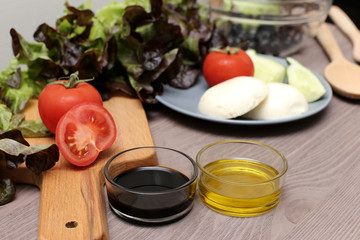 Salad mozzarella cheese tomatoes balsamic vinegar olive oil on a wooden board. Fresh food for diet product
