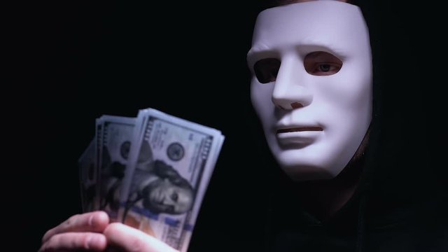 Hooded bandit in mask counting dollars, ransom for kidnapping victim, mafia