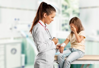 Young woman doctor with little girl  in a hospital