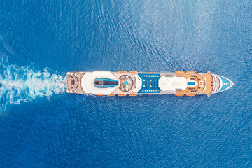 Cruise liner ship in ocean with blue water. Aerial top view