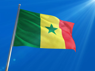 Senegal National Flag Waving on pole against deep blue sky background. High Definition