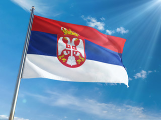 Serbia National Flag Waving on pole against sunny blue sky background. High Definition