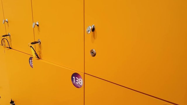 4k closeup video of camera slowly moving along row of yellow lockers in school