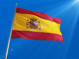 Spain National Flag Waving on pole against deep blue sky background. High Definition