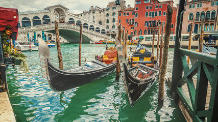 Fototapeta na wymiar Empty gondolas in front of Rialto Bridge. The bridge is a famous international landmark in Venice, Italy