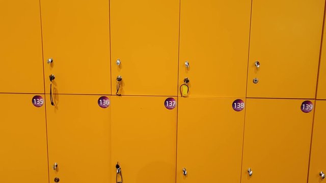 4k closeup video of camera slowly moving along row of yellow lockers in school