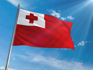 Tonga National Flag Waving on pole against sunny blue sky background. High Definition