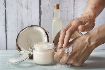 Human hands smearing homemade coconut and roses cream