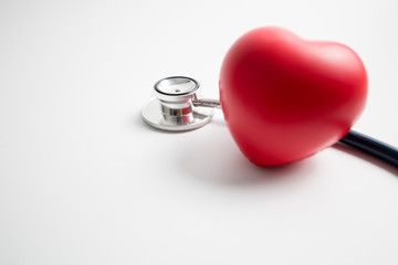 Red heart with stethoscope on white background