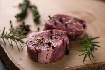 raw beef steak on wooden cutting board