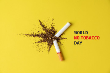Close up cigarette broken tobacco blast spread on yellow pastel background with light side and...