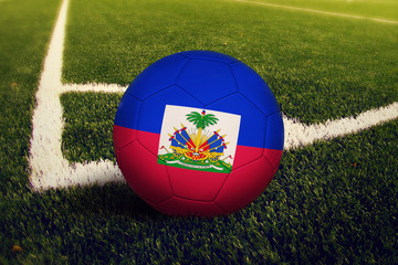 Haiti ball on corner kick position, soccer field background. National football theme on green grass.