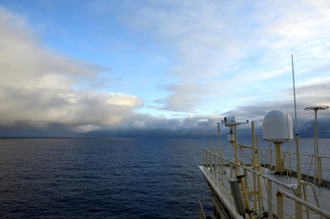 Naklejka na ściany i meble Cargo ship sailing through the Pacific Ocean, view from monkey island.
