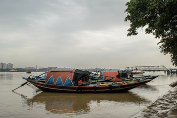 Fototapeta na wymiar Vidyasagar Setu bridge with wooden boat on Hoogly river.