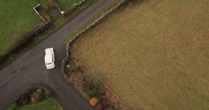 Classic Wedding car procession leaves church in Galway, Ireland. Aerial top down view