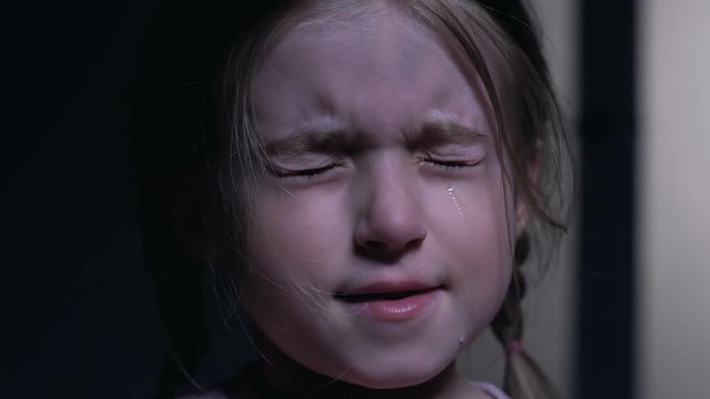 Cute little girl closing eyes from horror and crying, childhood fears, closeup