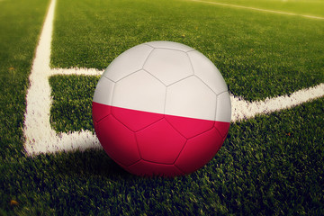 Poland ball on corner kick position, soccer field background. National football theme on green...