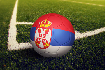 Serbia ball on corner kick position, soccer field background. National football theme on green...