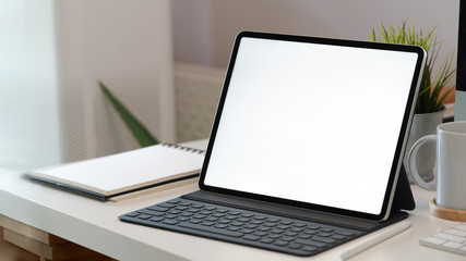 White screen tablet with smart keyboard on workspace desk