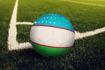 Uzbekistan ball on corner kick position, soccer field background. National football theme on green...
