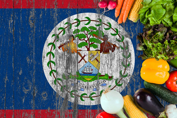 Fresh vegetables from Belize on table. Cooking concept on wooden flag background.