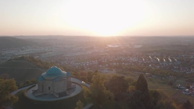 Aerial drone shot of beautiful Stuttgart, Germany while sunset with the Mercedes Benz Arena, the famous Volksfest Wasen and a lot of industry in the foreground and Stuttgart Downtown in the background
