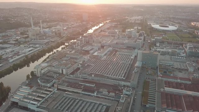 Aerial drone shot of beautiful Stuttgart, Germany while sunset with the Mercedes Benz Arena, the famous Volksfest Wasen and a lot of industry in the foreground and Stuttgart Downtown in the background