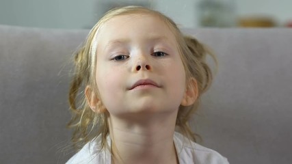 Adorable little girl with freckles looking in camera, preschool kid, childhood