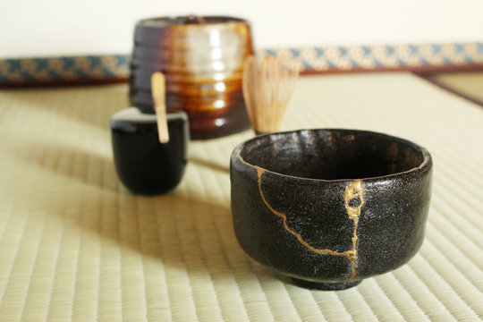 Kintsugi Black Raku Tea Bowl with Gold Repair in Japanese Tea Ceremony Room